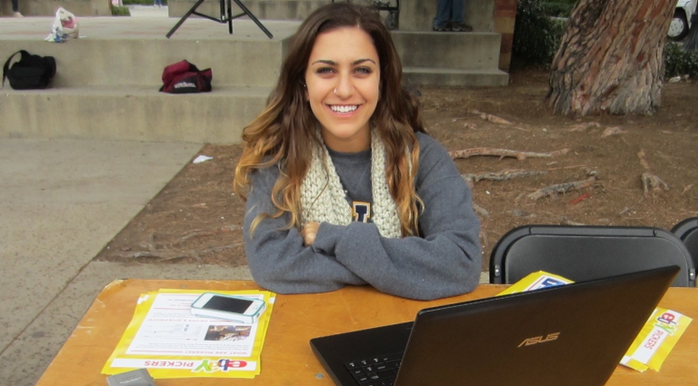 brand ambassador working at a table with a laptop and handouts